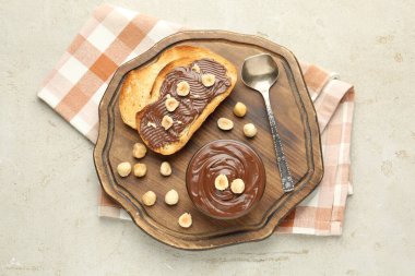 Lezzetli çikolatalı tostlar ve fındıklar ışık masasında.