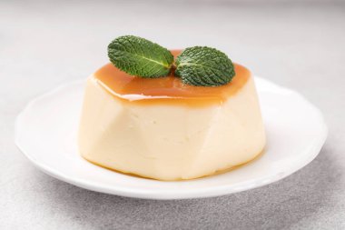 Karamel soslu lezzetli puding ve nane şekeri, yakın plan.