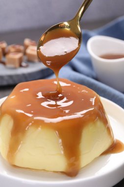 Masadaki pudingin üzerine karamel sosu dök.