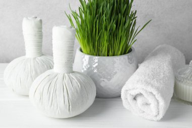 Açık gri arkaplana karşı beyaz masa üzerinde buğday çimi olan spa kompozisyonu, yakın plan
