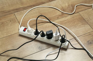 Uzatma güç panosu ahşap zemindeki prizlerle aşırı yüklendi