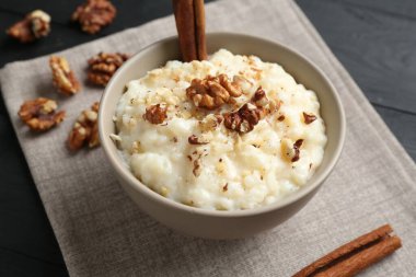 Siyah masada cevizli ve tarçınlı lezzetli sütlaç, yakın plan.