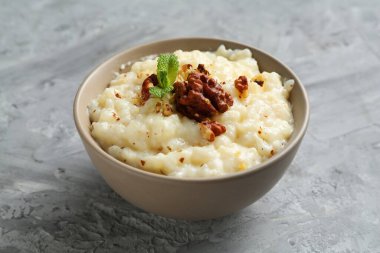 Gri masada cevizli ve naneli lezzetli sütlaç, yakın plan.