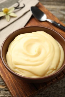 Tahta masada servis edilen lezzetli vanilyalı puding, yakın plan.