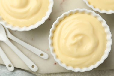 Işık masasında kaşıkları olan lezzetli vanilyalı puding.