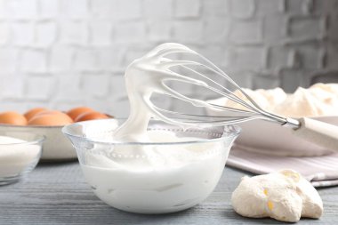 Krem şantili çırpma ve gri ahşap masadaki diğer malzemeler. Kurabiye pişiriyorum.