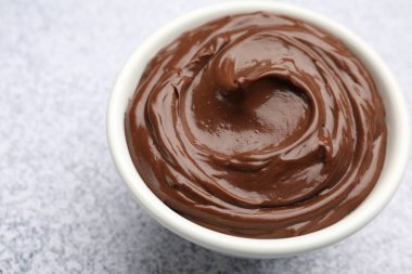 Açık gri desenli masada kasede nefis çikolatalı puding, yakın plan. Metin için boşluk