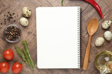Boş yemek tarifi kitabı ve ahşap masa üzerindeki ürünler. Tasarım için model