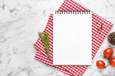 Boş yemek tarifi kitabı ve beyaz mermer masa üzerindeki ürünler. Tasarım için model