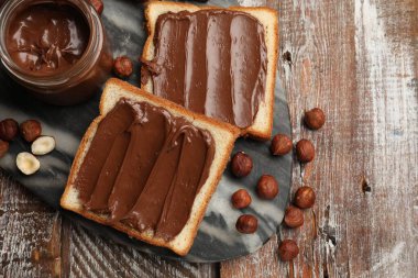 Lezzetli çikolatalı fındıklı tostlar ahşap masada fındıklar, düz yatış.
