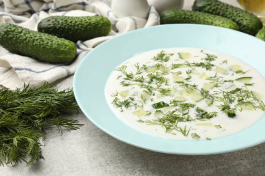 Gri desenli masada dereotlu salatalık çorbası, yakın plan.