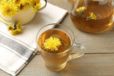 Tazeleyici karahindiba çayı ve çiçekler ahşap masada, yakın plan