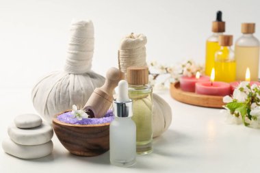Kozmetik ürünleriyle spa kompozisyonu, güzel çiçekler ve beyaz arka planda yanan mumlar, seçici odak