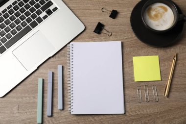 Defter, diğer kırtasiye malzemeleri, kahve ve dizüstü bilgisayar ahşap masa, düz uzanma