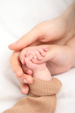 Anne, küçük bebeği evde, yatağında, yakın plan.