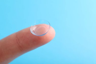 Açık mavi arka planda kontak lensli kadın, yakın plan. Metin için boşluk