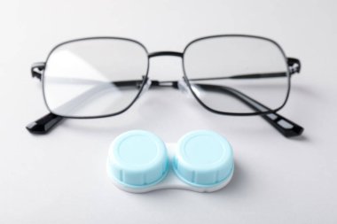 Beyaz arkaplanda kontak lensli ve gözlüklü dosya, yakın plan