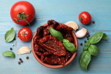 Lezzetli güneş, kasede kurutulmuş domatesler, taze sebzeler ve baharatlar açık mavi ahşap masa, düz yatıyordu.