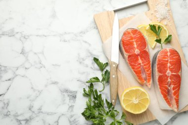 Deniz ürünleri. Taze çiğ somon bifteği, maydanoz, beyaz mermer masada bir parça limon ve bıçak, düz bir şekilde. Metin için boşluk