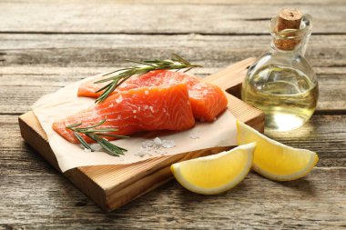 Deniz ürünleri. Somon filetosu, baharat, yağ ve limon dilimleri ahşap masada, yakın plan.