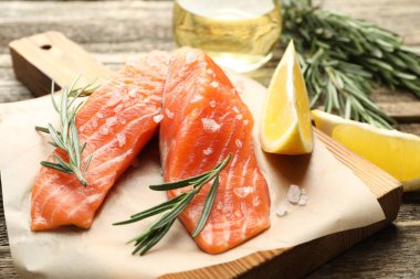 Deniz ürünleri. Somon filetosu, baharat, yağ ve limon dilimleri ahşap masada, yakın plan.