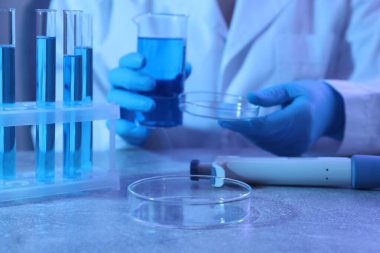 Petri kabında çalışan bilim adamı, yakın plan.