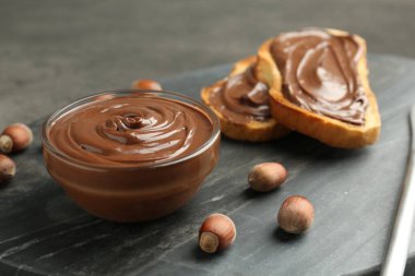 Lezzetli çikolata, tost ve fındık gri masada, yakın plan.