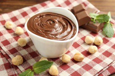 Lezzetli çikolata, parçalar, nane ve fındıklar masada, yakın plan.