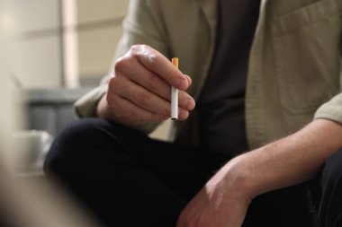 Arka planda sigara içen adam, yakın plan.