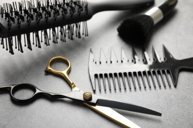 Gri masadaki farklı kuaför aletleri, yakın plan.