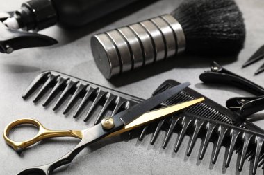 Gri masadaki farklı kuaför aletleri, yakın plan.