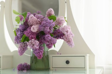 Soyunma odasındaki vazoda güzel leylak çiçekleri.