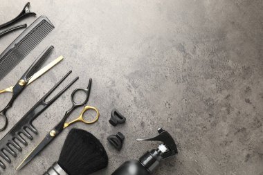 Gri masadaki farklı kuaför aletleri, düz yatış. Metin için boşluk