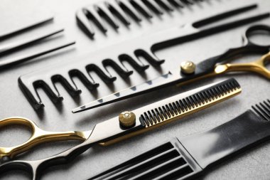 Gri masadaki farklı kuaför aletleri, yakın plan.