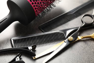 Gri masadaki farklı kuaför aletleri, yakın plan.