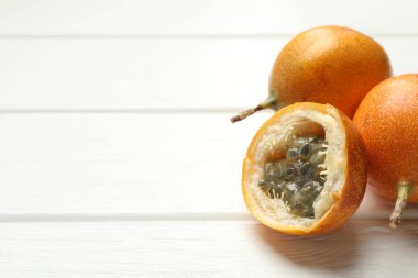 Olgun tutku meyveleri beyaz ahşap masada, yakın plan. Metin için boşluk