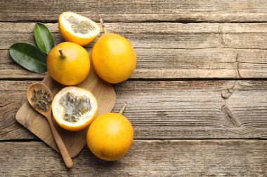 Olgun tutku meyveleri, tohumlar ve yapraklar ahşap masada, düz yerde. Metin için boşluk