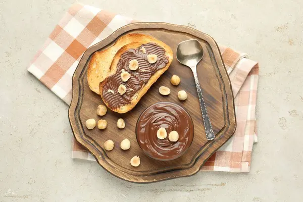 Lezzetli çikolatalı tostlar ve fındıklar ışık masasında.