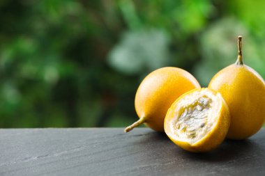 Açık havada, siyah masada olgun tutku meyveleri, yakın plan. Metin için boşluk
