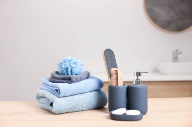 Banyodaki hafif ahşap masada farklı banyo ürünleri.