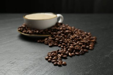 Kahve fincanda, fasulye siyah masada, yakın plan.