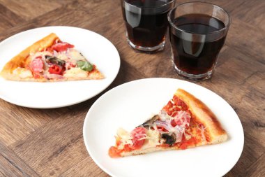 Ahşap masada servis edilen ince füme sosisli, lezzetli pizza dilimleri.