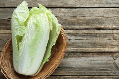 Tahta masada sepetin içinde taze Çin lahanası, üst manzara. Metin için boşluk