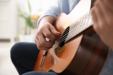 Evde gitar çalan adam, eline odaklan.