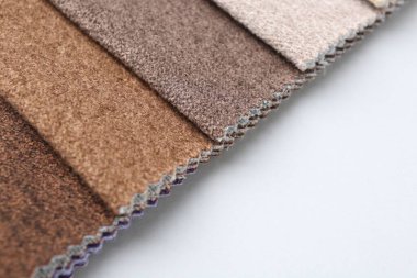 Beyaz arka planda farklı kumaş örnekleri, yakın plan. Metin için boşluk