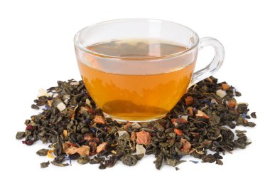 Cam fincanda nefis bitki çayı ve beyaz yaprakların üzerinde kuru yapraklar.