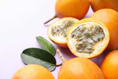 Olgun sarı çarkıfelek meyveleri ve leylak kaplamalı yapraklar, yakın plan. Metin için boşluk