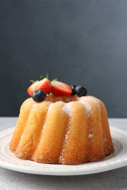Açık gri masada pudra şekeri ve böğürtlenli Lezzetli kek, yakın plan. Metin için boşluk