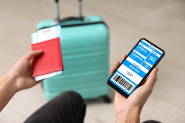 Otobüs ve pasaport için e-bileti olan cep telefonlu turistler, yakın plan.