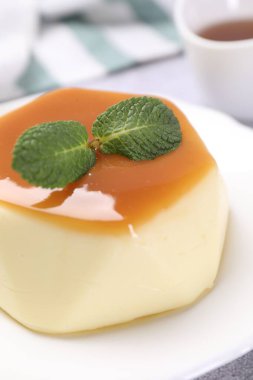 Karamel soslu lezzetli puding ve nane şekeri, yakın plan.
